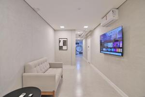 a living room with a couch and a tv on a wall at Premium Office-My Stay 02 in Brasília