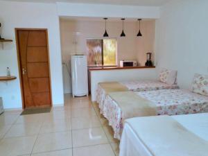 a hotel room with two beds and a refrigerator at Chalé Recanto Luz Da Montanha in Águas de Lindoia +82 photos