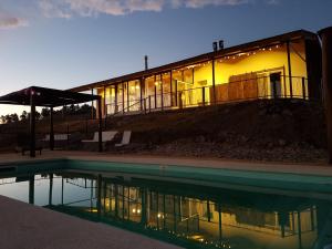 a building with a pool in front of it at Colores de Yacanto in Villa Yacanto