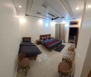 a bedroom with two beds and a couch and chairs at Shree Rameshwaram Retreat in Gupta Kāshi +10 photos