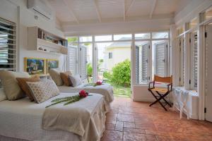 a bedroom with two beds in a room with windows at 3BR Beachfront Villa w/ Staff-DRMNV in Duncans