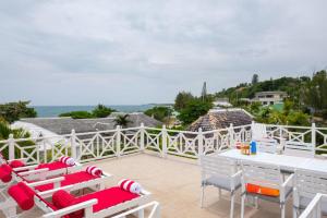 a patio with red and white chairs and a table at 3BR Beachfront Villa w/ Staff-DRMNV in Duncans