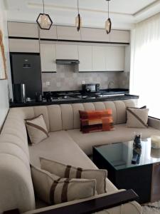 a living room with a large couch and a kitchen at Appartement suite in Cabo Negro