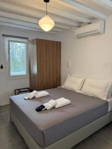 a bedroom with a large bed with two towels on it at Green Dream Tinos in Tinos