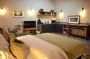 a living room with a bed and a desk at Oak field Cottages Belfast open plan studio stunning & tranquil in Dunmurry