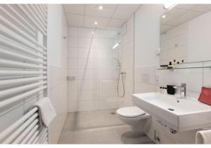 a white bathroom with a toilet and a sink at Brera Stuttgart in Stuttgart