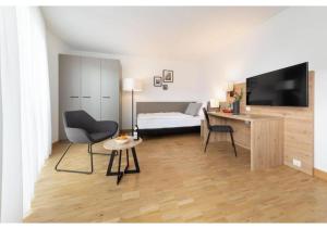 a living room with a bed and a television and a table at Brera Stuttgart in Stuttgart +36 photos