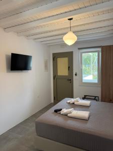 a bedroom with a bed with two towels on it at Green Dream Tinos in Tinos