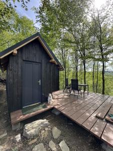 a cabin with a bench on a wooden deck at Dealul Notarasului Retreat in Gara Piatra Craiului