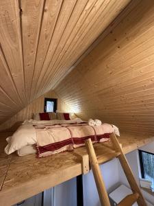 a bed sitting on a wooden platform in a cabin at Dealul Notarasului Retreat in Gara Piatra Craiului