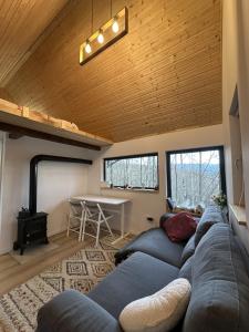 a living room with a couch and a table at Dealul Notarasului Retreat in Gara Piatra Craiului
