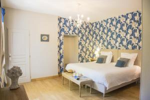 a bedroom with a bed with a blue and white wallpaper at Château Pech-Céleyran in Salles-dʼAude