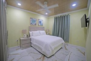 a bedroom with a white bed with a marble floor at 3BR Modern Villa w/ Private Pool & Fire Pit in Saint Philip +26 photos
