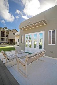 a patio with two lounge chairs at 3BR Modern Villa w/ Private Pool & Fire Pit in Saint Philip