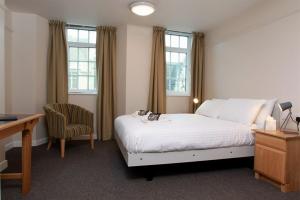 a bedroom with a bed with a desk and a chair at 117 St Aldates Christ Church Accommodation in Oxford +9 photos