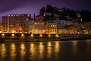 a city at night with a river and buildings at La Maison in Salzburg +13 photos