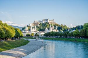 a view of a river with a castle in the background at La Maison in Salzburg