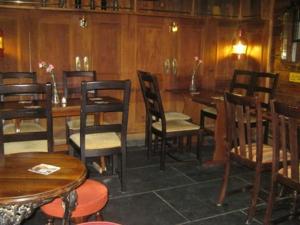 a restaurant with wooden tables and chairs and wooden walls at The Ship Inn in St Austell