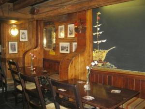 a dining room with a table and chairs and a wall at The Ship Inn in St Austell +6 photos