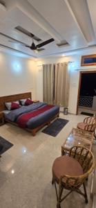 a bedroom with a bed and chairs and a ceiling fan at Shree Rameshwaram Retreat in Gupta Kāshi