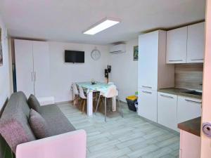 a kitchen and a living room with a table and a couch at TERRA HOME Gaeta - Moderno Bilocale nel Borgo in Gaeta