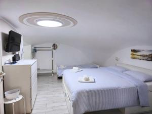 a bedroom with two beds and a tv and a ceiling at TERRA HOME Gaeta - Moderno Bilocale nel Borgo in Gaeta