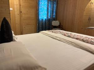 a bedroom with two beds and a window at Favela Headrooms in Srinagar