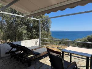 a patio with a table and chairs and the ocean at Ageranos in Vathi +30 photos