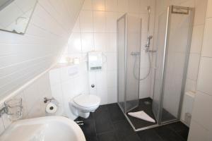 a white bathroom with a shower and a toilet at Finnhütte Achtern in Wustrow +10 photos