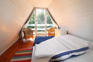 a bedroom with a bed and a large window at Finnhütte Achtern in Wustrow