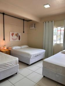 a bedroom with two beds and a window at Pousada Rota do Parque in Penha