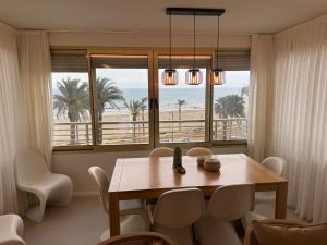 a dining room with a table and a view of the beach at Apartamento 1ª LINEA PLAYA MUCHAVISTA in El Campello +27 photos