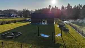 a small building with a bunch of golf equipment in a field at Dom w czerni in Górniki