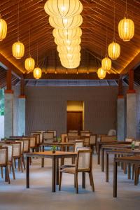a restaurant with wooden tables and chairs and lights at Cascara Resort Weligama - A Tropical Sanctuary in Weligama
