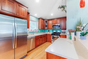 a kitchen with wooden cabinets and a stainless steel refrigerator at Old River Hideaway in Guerneville