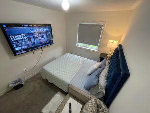 a bedroom with a bed and a flat screen tv at Relax Guest House in Oshawa