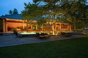 a building with a courtyard with a tree and benches at Cascara Resort Weligama - A Tropical Sanctuary in Weligama