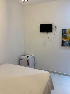 a bedroom with a bed and a tv on the wall at Hotel pousada czar in João Pessoa