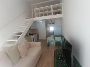 a living room with a white couch and a staircase at Tomarhousing - City Centre in Tomar