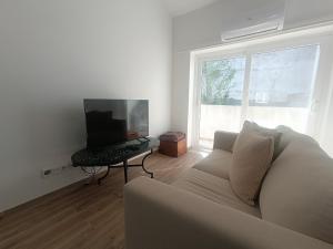 a living room with a couch and a computer on a table at Tomarhousing - City Centre in Tomar