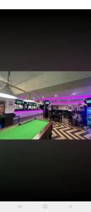 a ping pong room with a pool table and purple lights at The Cavern Retreat in Rhyl