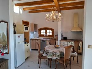 a kitchen with a table and chairs and a chandelier at ZanZebil in Zebil