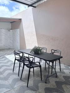 a black table and chairs with a potted plant on it at Casa IBM - Crato in Crato