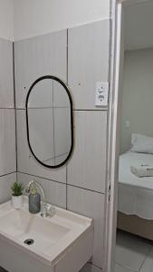a bathroom with a mirror and a sink and a bed at Casa IBM - Crato in Crato
