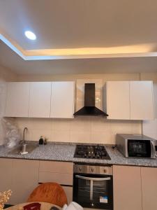 a kitchen with a stove and a microwave at Cocon de paix à Ngor Virage in Dakar