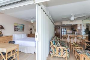 a bedroom with a bed and a table and a kitchen at Ilikai Tower 1314 in Honolulu