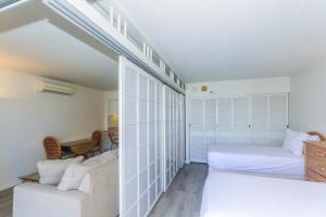a white bedroom with a bed and a couch at Ilikai Tower 1403 in Honolulu +20 photos