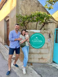 a man and a woman holding a baby in front of a sign at B&B Casa Ellie in Tormos