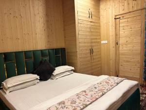 a bed with a green headboard in a room at Favela Headrooms in Srinagar