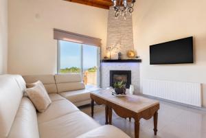a living room with a couch and a fireplace at Villa Stone House in Neo Chorio